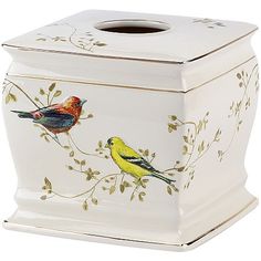 two birds painted on the side of a white tissue dispenser with gold trim