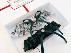 two garters in a white box with green ribbon