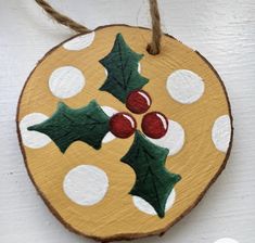 a wooden ornament decorated with holly and berries