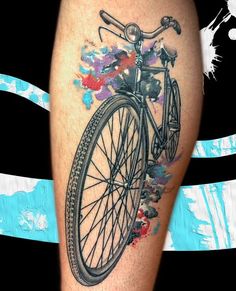 an artistic tattoo on the leg of a man with a bicycle painted on it's side