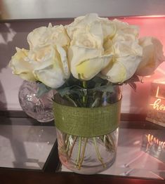 some white roses are in a glass vase