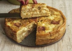 a person cutting into a pizza on top of a plate with a knife in it