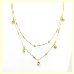 This beautiful necklace has a unique design - a very long chain that can be worn long or doubled, with the help of a toggle closure. It features tulip-shaped crystal drops set along half of the chain. Made of durable and beautiful 14kt gold-plated brass and enhanced with the finest European crystals. The full length is 42" or 20" when doubled. Made in the USA by La Vie Parisienne Gold Dangle Crystal Necklaces, Gold Drop Chain Necklaces, Gold Cubic Zirconia Crystal Necklaces For Jewelry Making, Elegant Layered Dangle Chain Necklace, Elegant Gold Drop Crystal Necklaces, Gold Cubic Zirconia Crystal Necklace For Jewelry Making, Gold Crystal Lariat Necklace, Gold Long Drop Chain Necklaces, Gold-plated Long Drop Necklace With Delicate Chain