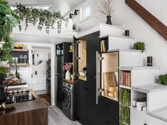 an open cabinet in the middle of a kitchen next to a washer and dryer