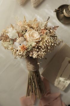 a bouquet of flowers sitting on top of a table next to napkins and other items