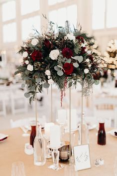 an image of a table setting with flowers in vases and place cards on it