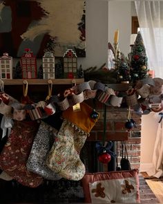 stockings hanging from a fireplace in front of a christmas tree