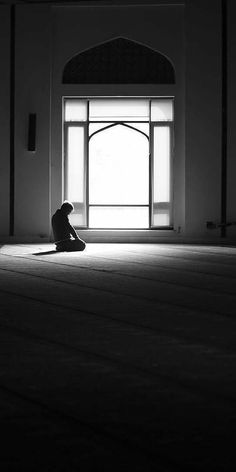 a person sitting on the floor in front of a window with sunlight streaming through it