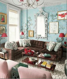 a living room filled with furniture and a chandelier hanging from the ceiling in front of a window