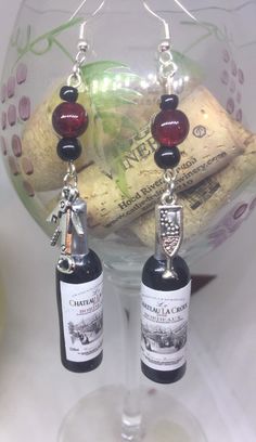 two bottles of wine are hanging from the corks in front of a glass bowl