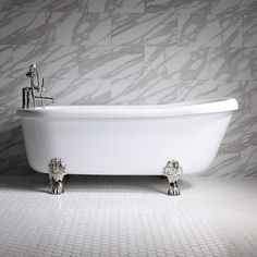 a white bath tub sitting on top of a bathroom floor next to a wall mounted faucet