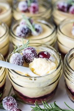 small jars filled with desserts covered in powdered sugar and cranberry sauce