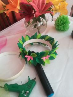 some paper flowers are on a table with scissors and other crafting supplies next to it