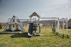 there is a playground in the middle of a field with a slide and climbing frame