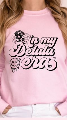 a woman wearing a pink sweatshirt with black lettering