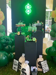 the table is set up with green balloons and dollar signs on it, along with other decorations