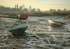 two boats sitting on top of a muddy beach