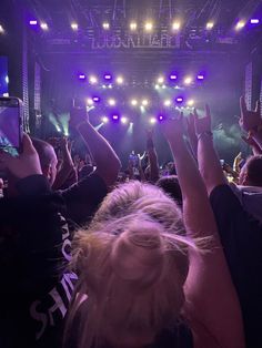 a group of people at a concert with their cell phones in the air and lights on