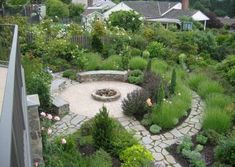 an outdoor fire pit surrounded by greenery and landscaping