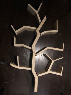 a tree made out of books sitting on top of a wooden floor in the dark