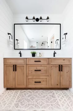 a bathroom with a large mirror and wooden cabinets