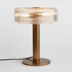 a table lamp that is on top of a wooden base and has a glass shade