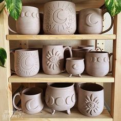 a shelf filled with ceramic pots and mugs