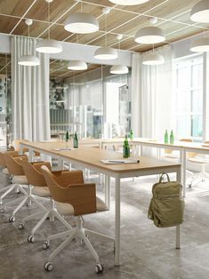 a long table with chairs and bottles on it in front of large windowed windows