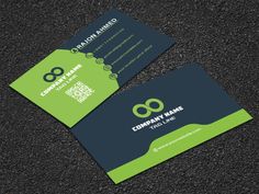 two green and black business cards sitting on top of a dark surface with the letter o