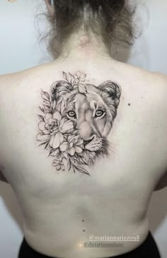 a woman's back with a lion and flowers on it