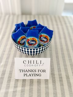 a bowl filled with chips sitting on top of a table next to a sign that says chili cook - off thanks for playing