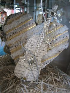 a musical instrument made out of sheet music with pearls and beads hanging from it's sides