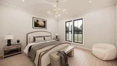 a bedroom with white walls and wood flooring has a large bed in the center