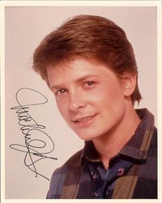 an autographed photograph of a man with brown hair and plaid shirt smiling at the camera