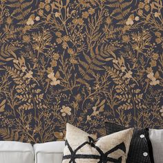 a living room with a couch and wallpaper that has gold flowers on black background