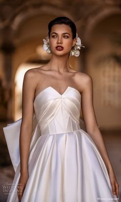 a woman in a white dress with flowers on her head