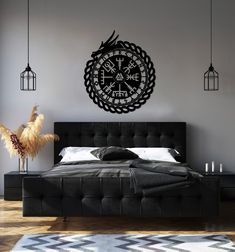 a bedroom with a bed, black headboard and large clock on the wall above it