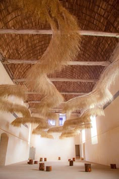 an empty room with straw hanging from the ceiling