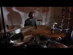 a man sitting in front of a drum set