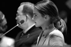 a woman sitting next to a man at a microphone