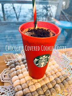 a red cup filled with chocolate covered cookies and a candy cane sticking out of it