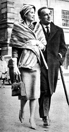 an old photo of a man and woman walking down the street