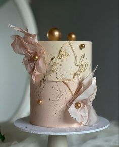 a pink cake with gold decorations on top