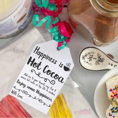 there is a sign that says happiness is hot cocoa next to some sugar and sprinkles