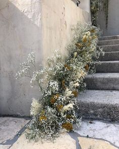 some white and yellow flowers sitting on the steps