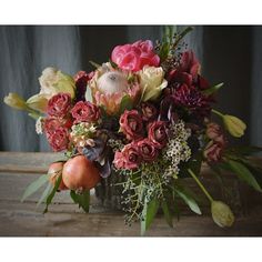 a vase filled with lots of different types of flowers