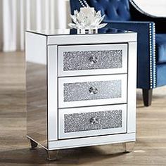 a white and silver night stand with two drawers on the bottom, in front of a blue chair