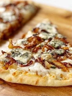 two slices of pizza sitting on top of a wooden cutting board