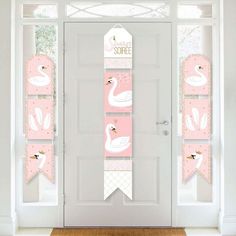 the front door is decorated with pink and white swan banners, which are hanging from hooks