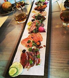 a long table topped with lots of different types of food and glasses filled with drinks